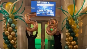 People holding balloons with number 58.