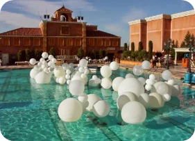 White balloons floating in a pool.