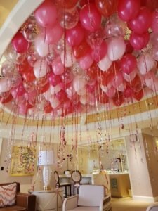 Ceiling decorated with pink and red balloons.