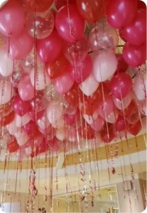 Pink and red balloons on ceiling display.