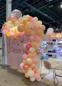 Balloon arch at a beauty product booth.