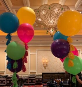 Colorful balloons with tassels in a room.