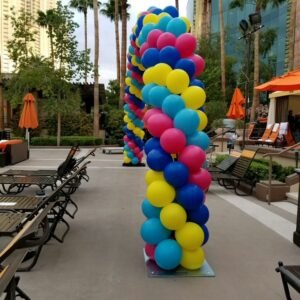 Colorful balloon arch by poolside lounge.