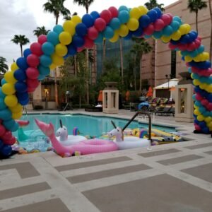 Pool with unicorn floats and balloon arch.
