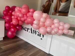 Pink balloon arrangement on white counter.