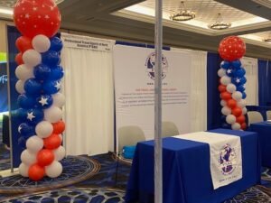 Trade show booth with patriotic balloon columns.