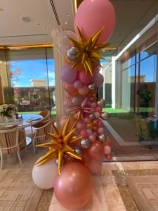 Colorful balloon arrangement with gold star accents.