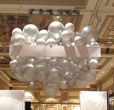 Silver balloons suspended in elegant indoor setting.