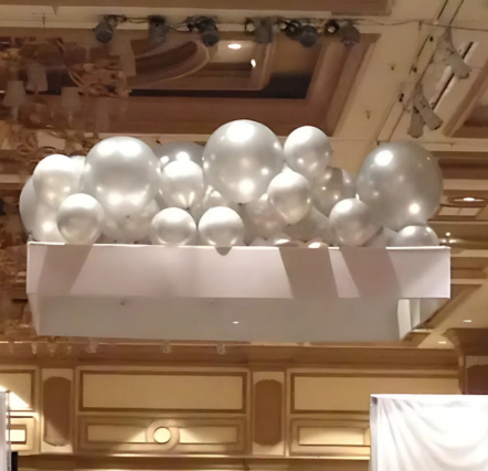 Silver balloons attached to a ceiling structure.