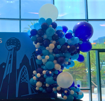Blue and white balloon decoration near window.