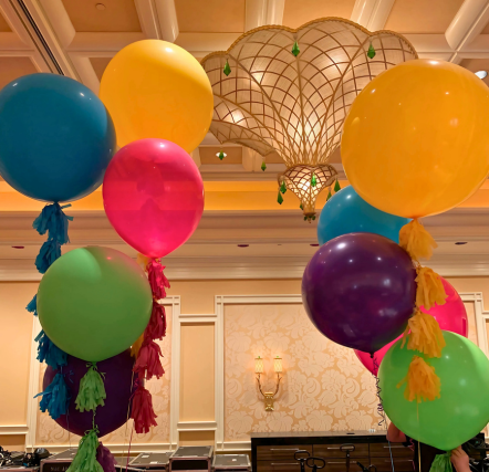 Colorful balloons with tassels in elegant room.