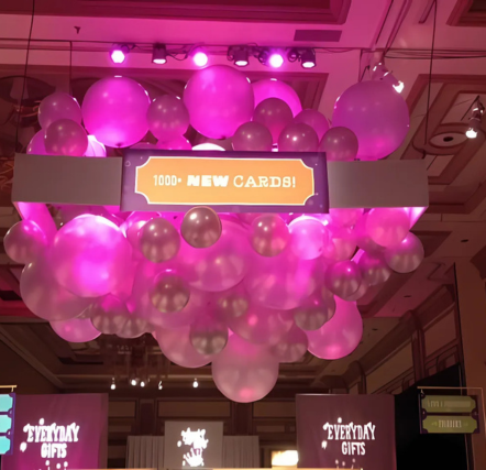 Pink balloons with "New Cards" sign display.