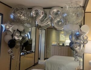 Silver 28th birthday balloons in room.