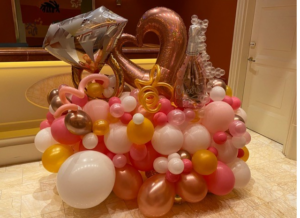 Balloon arrangement with champagne and ring decorations.