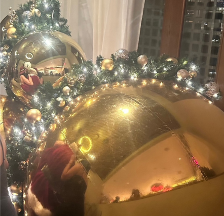 Christmas tree with large gold ornaments.