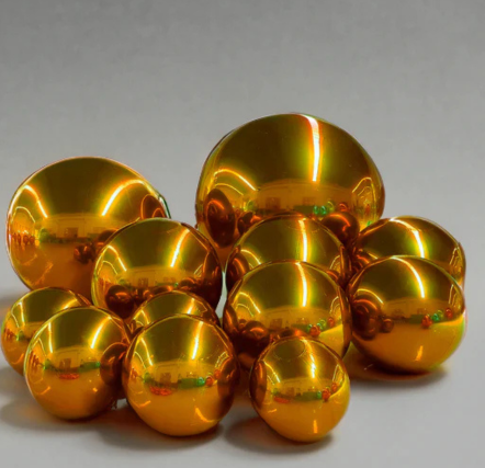 Golden reflective spheres clustered on grey background.