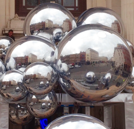 Reflective silver spheres with cityscape reflections.