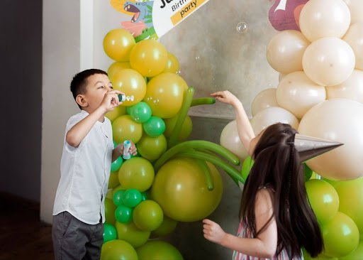 Colorful celebration balloons in Las Vegas, set up with kids playing happily at a party, creating a joyful and vibrant event atmosphere